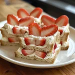 Juicy heart-shaped sandwiches with a creamy layer, showcased on a simple plate.