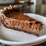 Layered sugar-free dessert in a pan, highlighting the creamy filling and chocolate crust.