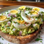Juicy avocado egg salad toast garnished with fresh herbs and paprika.