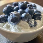 Detailed image of yogurt-coated blueberries, frozen into bite-sized clusters.