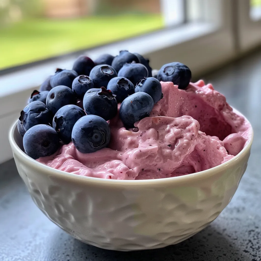 Fresh blueberries surrounded by a thick layer of vanilla yogurt, presented as a frozen treat.