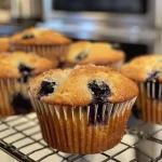 Juicy lemon blueberry muffins on a plate showcasing their textured muffin tops and fresh fruit.