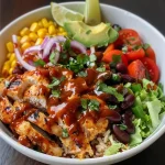 Side view of a hearty BBQ Chicken Power Bowl showcasing fresh ingredients.