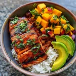 Delicious BBQ salmon served with fresh mango and avocado salsa in a bowl.
