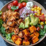 Juicy BBQ chicken served in a bowl with sweet potatoes, corn, cherry tomatoes, avocado, and Greek yogurt.