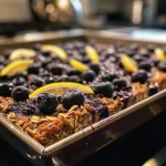 A hearty slice of lemon blueberry breakfast bake, topped with fresh blueberries.