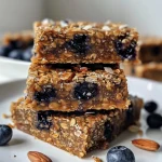 Juicy No Bake Blueberry Muffin Breakfast Bar showing chunks of dried blueberries and a glossy top.