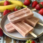 Juicy strawberry banana protein popsicles with bright colors, showcasing their fruity ingredients.