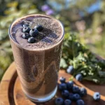 ['Close-up view of a vibrant blue and yellow smoothie in a glass, garnished with blueberries and lemon slices.', 'Side profile of a refreshing lemon blueberry smoothie with visible blueberries and a lemon slice on the rim.', 'Juicy anti-inflammatory smoothie in a clear glass, featuring blueberries and lemon zest on top.', 'A delicious-looking smoothie with blueberry and lemon colors, showcasing a creamy texture and fresh ingredients.']