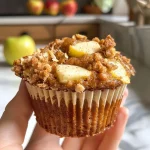 ['Close-up side view of moist apple cinnamon muffins with a golden-brown crust.', 'Freshly baked apple cinnamon muffins displayed on a wooden surface.', 'Delicious apple cinnamon muffins with chunks of apple visible in the batter.', 'Side view of fluffy muffins, showcasing a sprinkle of cinnamon on top.']