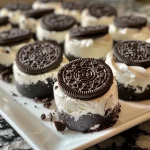 ['Close-up view of healthy no-bake Oreo cheesecake bites stacked on a plate.', 'Side view of creamy cheesecake bites topped with crushed Oreo thins and placed on a wooden table.', 'Delicious no-bake Oreo cheesecake bites with a glossy appearance, showcasing layers of cream cheese and yogurt.', 'A tempting arrangement of Oreo cheesecake bites against a rustic backdrop, highlighting their texture.']