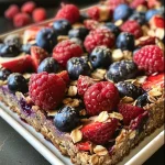 ['Close-up view of a baked dessert featuring mixed berries and a golden crust.', 'Side angle of a High Protein Triple Berry Bake, showcasing juicy berries and a crumbly top.', 'Detailed view of a healthy berry bake with a rich texture and vibrant colors.', 'Luscious slice of berry cake highlighting strawberries, blueberries, and raspberries.']