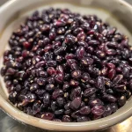 ['Close-up view of cooked Riceberry grains, showcasing their unique purple hue and texture.', 'Side view of a bowl filled with fluffy Riceberry, highlighting its shiny surface and distinct color.', 'Detailed shot of Riceberry grains, revealing their rich purple color and plump appearance.', 'Close-up image of Riceberry with water droplets, emphasizing freshness and quality.']